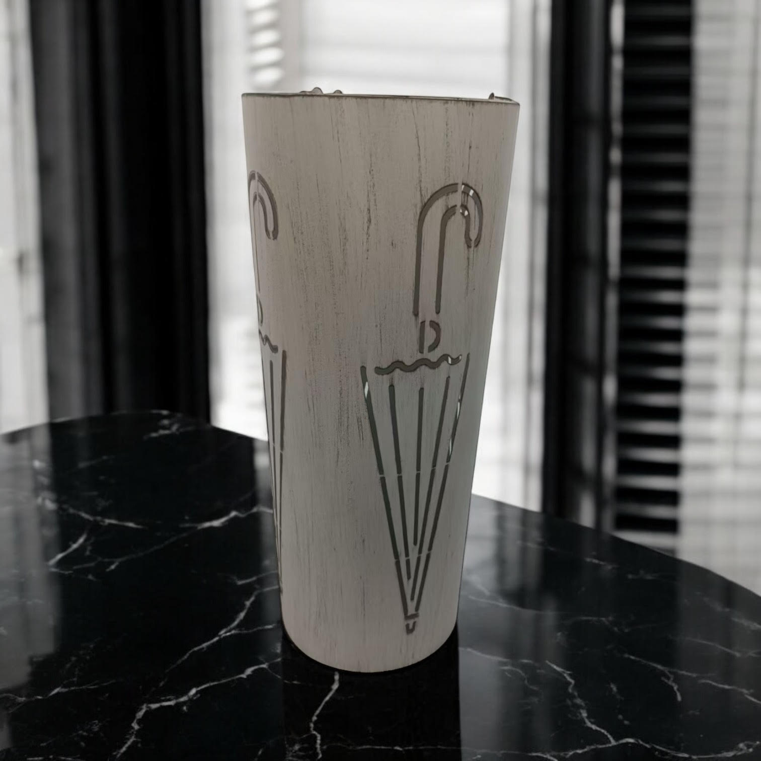 Cream metal umbrella stand, 49cm tall with a sleek design, featuring multiple compartments for organizing umbrellas.