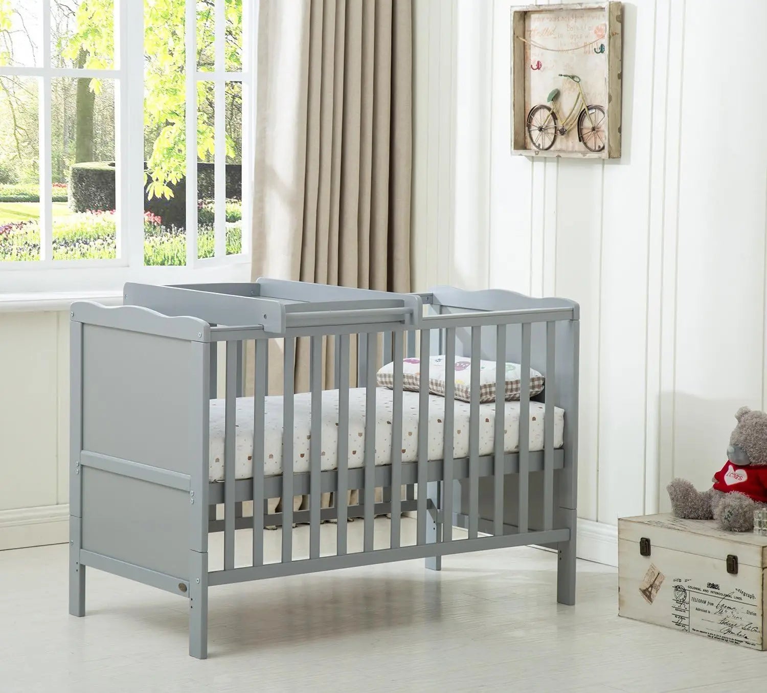 Wooden baby cot bed Orlando by Livoshop with top changer and aloe vera water-repellent mattress in a nursery setting