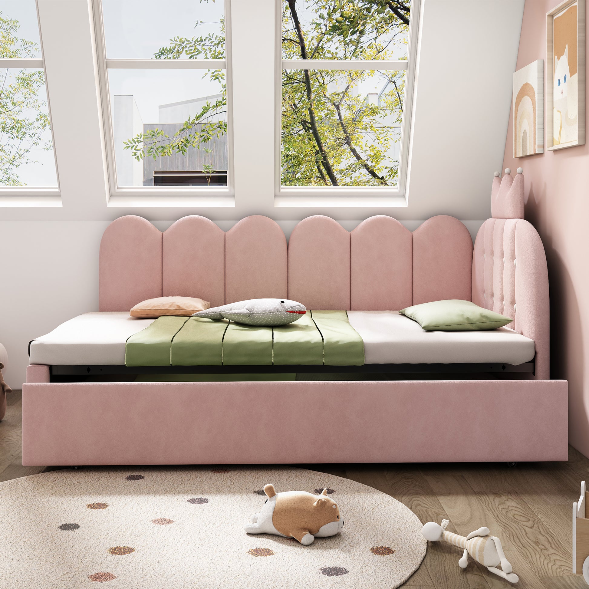 Pink velvet upholstered daybed with crown-shaped trundle, metal slatted frame, pull-out bed, ideal for guests, no mattress included.