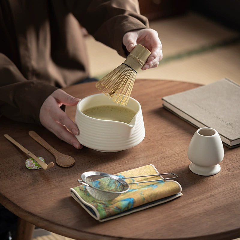 Premium 8-piece Matcha tea set with ceramic chawan bowl, whisk, and gift box in gradient pink and green colors.